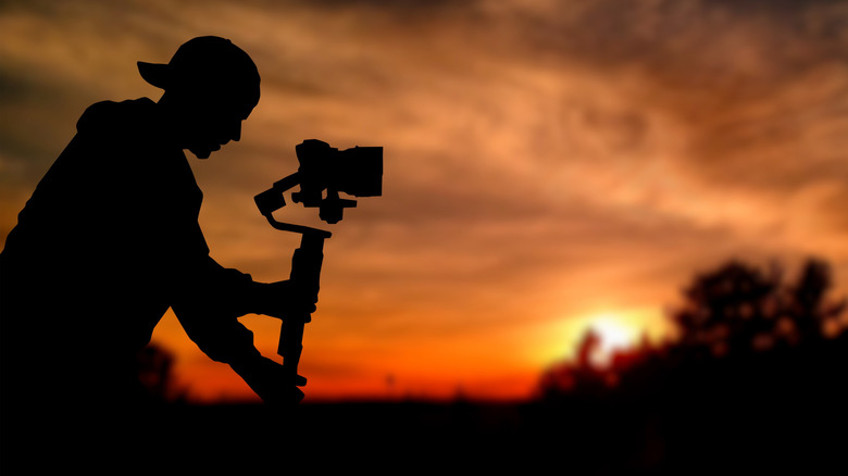a man capturing sunset with gimble camera